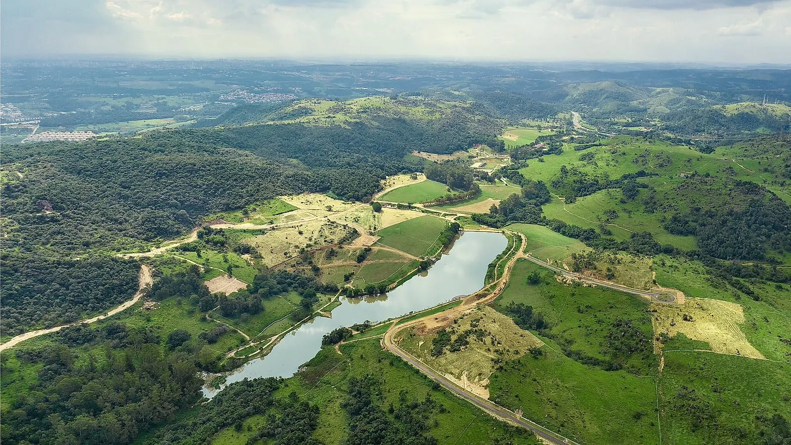 Vista aérea do vale: o espelho d'água ao centro, a mata nas encostas e os platôs abertos que fazem cada estância diferente da outra
